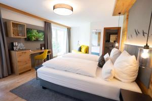a hotel room with two beds and a desk at Alpenhof Oberstdorf Hotel & SPA, Signature Collection by BW in Oberstdorf