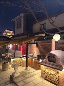 a outdoor kitchen with a brick oven in a backyard at Dali Wenshuo Ancient City Center Private Courtyard Hotel in Dali Ancient Town