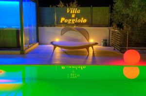 um banco sentado em frente a um edifício com luzes em Appartamenti Villa il Poggiolo em Diano Marina