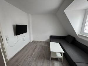 a white room with a bench and a tv on the wall at TopLageDG in Augsburg