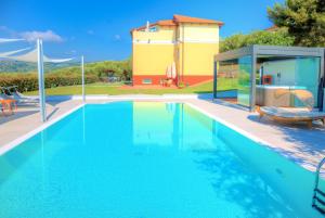 une piscine avec une maison en arrière-plan dans l'établissement Appartamenti Villa il Poggiolo, à Diano Marina