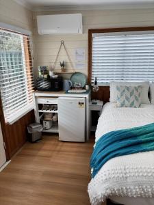 ein kleines Schlafzimmer mit einem Bett und einem Schreibtisch in der Unterkunft Stonez Boutique Accommodation in Clunes