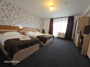 a hotel room with two beds and a window at Poiana Bucovat in Gura Humorului
