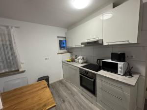 a small kitchen with a microwave and a stove at TopLageEG in Augsburg +6 photos
