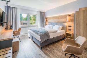 ein Schlafzimmer mit einem Bett, einem Schreibtisch und einem Fernseher in der Unterkunft Best Western Hotel Brunnenhof in Weibersbrunn