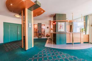 a lobby with green floors and blue cabinets at PLAZA INN Blankenburg Ditzingen, Sure Hotel Collection in Ditzingen