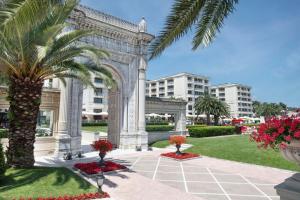 a building with a palm tree in a park at Çırağan Palace Kempinski Istanbul in Istanbul