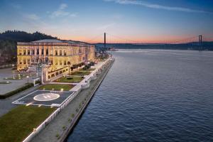 a large building next to the water with a bridge at Çırağan Palace Kempinski Istanbul in Istanbul