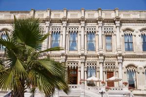 a large building with a palm tree in front of it at Çırağan Palace Kempinski Istanbul in Istanbul