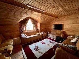 a room in a log cabin with couches and a window at Ahşap Tatil Evi in Çamlıhemşin