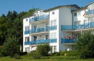 オストゼーバート・ゼリンにあるFerienwohnung "Bellevue" in Sellin auf Rügenの青いバルコニー付きの白いアパートメントビル