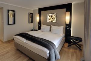 a bedroom with a large white bed with a blanket on it at Hofhotel Grothues-Potthoff in Senden +30 photos