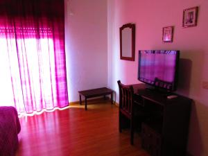 una sala de estar con TV de pantalla plana en una cómoda en ATCamões, en Almodôvar