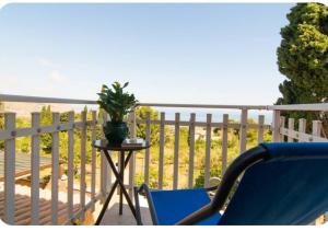 a blue chair sitting on a balcony with a plant at Dream on the blue house 2 in Valderice