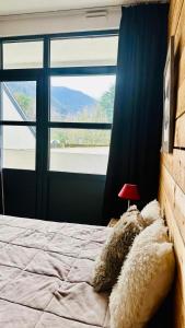 a bedroom with a bed with a large window at Nid cosy avec vue montagne au coeur de saint lary in Saint-Lary-Soulan +22 photos