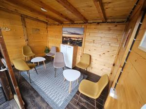 a room with tables and chairs in a wooden room at Vila Đukić Zlatibor in Zlatibor