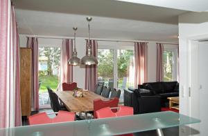 uma sala de jantar e sala de estar com mesa e cadeiras em Dünenresidenz Glowe - Ferienhaus Maxi 200 m zum Strand em Glowe