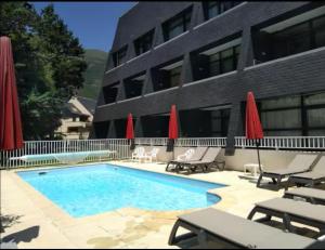 a swimming pool in front of a building at Nid cosy avec vue montagne au coeur de saint lary in Saint-Lary-Soulan