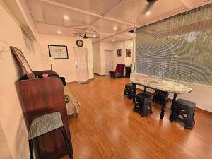 a living room with a piano and a table at Third Eye Homestay in Cochin