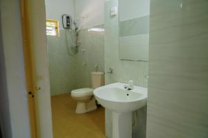 ein weißes Badezimmer mit Toilette und Waschbecken in der Unterkunft Golden Beach Hotel & Restaurant in Trincomalee