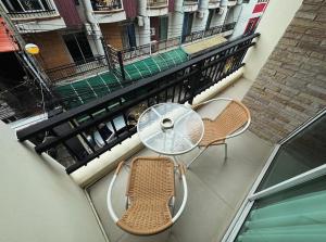 een glazen tafel en 2 stoelen op een balkon bij Cloud9 Reloaded in Pattaya