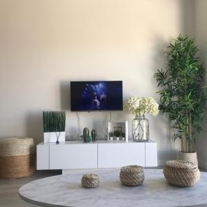 a white living room with a tv on a wall at ValleNiza beach loft in Almayate Alto