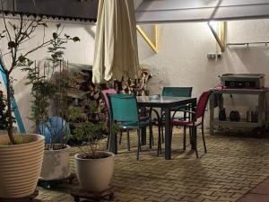 una mesa y sillas en una habitación con plantas en 3 pieces avec terrasse entre plage et centre ville, en Arcachon