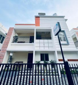 Una casa blanca con un cartel delante en Rizz Villa, en Trivandrum