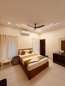 Un dormitorio con dos camas y un televisor. en Rizz Villa, en Trivandrum