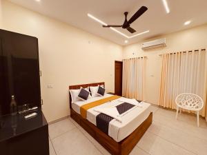 Un dormitorio con una cama y un ventilador de techo. en Rizz Villa, en Trivandrum