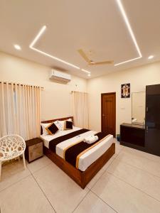 Un dormitorio con una cama y una silla en una habitación. en Rizz Villa, en Trivandrum 4 fotos más