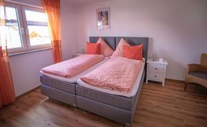 a bedroom with a large bed with red pillows at Fuchsbau Erdgeschoß in Burtenbach