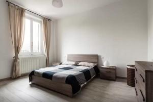 a bedroom with a large bed and a window at Appartamento Ai Giardini in Empoli