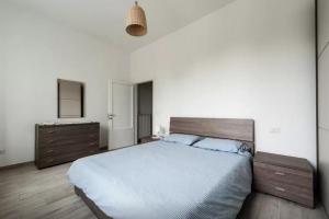 a bedroom with a large bed and a dresser at Appartamento Ai Giardini in Empoli