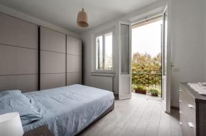 a bedroom with a large bed and a large window at Appartamento Ai Giardini in Empoli