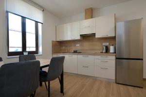 a kitchen with a table and chairs and a refrigerator at Apartmaji Siliganum in Nova Gorica