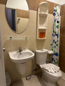 a bathroom with a sink and a toilet and a mirror at Garden Guest House in Pattaya Central