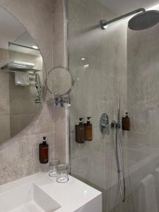 a bathroom with a shower with a sink and a mirror at Rahat Palace Hotel in Almaty
