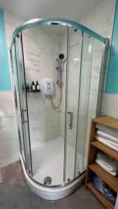a shower with a glass enclosure in a bathroom at Spacious and homely city centre studio in Coventry +19 photos