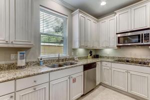a kitchen with white cabinets and a sink and a window at 2142 Cape Sound in Fernandina Beach +52 photos