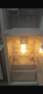 an empty refrigerator with its door open and its light on at Ap da AnaLu no Guarú in Guarujá