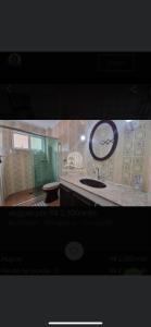 a bathroom with a sink and a large mirror at Ap da AnaLu no Guarú in Guarujá