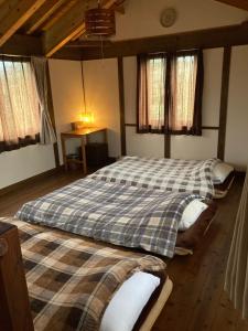 two beds sitting in a room with windows at koco in Nishinoomote +7 photos
