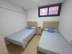 a bedroom with two beds and a window at BALERMA PLAYA. Calle Santa elena in El Ejido
