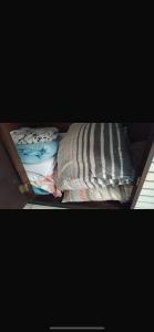 a small bed with sheets and pillows on it at Ap da AnaLu no Guarú in Guarujá +9 photos