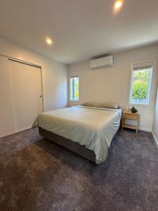 a bedroom with a large bed and a window at Luxury stay in Tutukaka in Whangarei