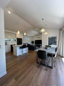 a living room and kitchen with a table and chairs at Luxury stay in Tutukaka in Whangarei
