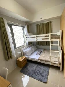 a bedroom with two bunk beds and a window at Theodore Alfonzo rental in Manila
