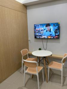 a room with a table and a tv on a wall at Theodore Alfonzo rental in Manila