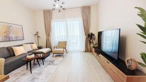 un soggiorno con divano e TV a schermo piatto di 2br Spacious Apt At Yas Island a Abu Dhabi